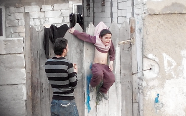 Presa engleză e oripilată din nou de imaginile din România: Copil agăţat în gard la uscat