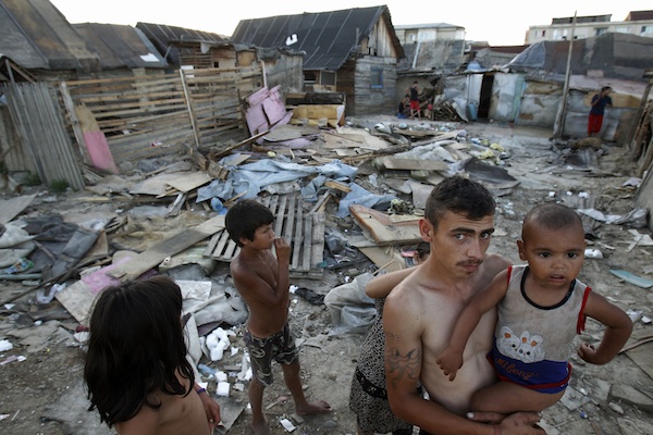 Ethnic Roma people are seen in Craica slum in Romania's northern town of Baia Mare, 550 km (341 miles) northwest of Bucharest, June 18, 2012. Roma is a term for various groups who have migrated across Europe for centuries and are now the biggest ethnic minority in the European Union, most of them from countries like Romania, Bulgaria and the Czech Republic. There are an estimated 10 million across Europe and one in five lives in Romania. The vast majority live on the margins of society in abject poverty, which makes them easy targets in troubled times, and pro-democracy groups say post-communist governments in the region have not done enough to improve their plight. Picture taken June 18, 2012. To match Feature ROMANIA-ROMA/ REUTERS/Bogdan Cristel (ROMANIA - Tags: POLITICS SOCIETY IMMIGRATION REAL ESTATE BUSINESS)